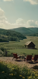 two chairs are on the grass near a table and barn
