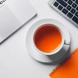 a cup of tea and an opened laptop computer
