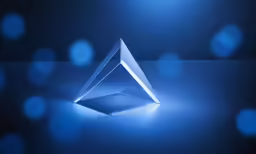 the modern blue glass sculpture is placed on a dark surface