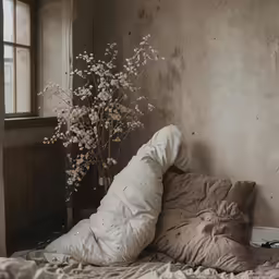 an unmade bed and pillow in a room with an open window