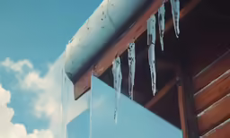 icicles on a house roof, which looks like they have been melted