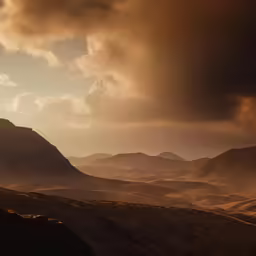 the view over the mountains with dark clouds in the background