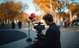 the cameraman is filming in front of a street sign