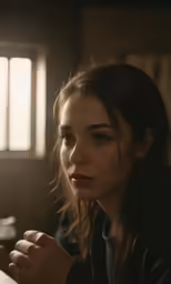 a young woman sits in an empty room and stares at something