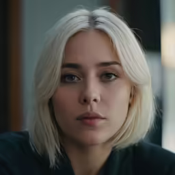 blonde woman looking to the side with serious face