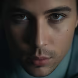 a man with eye color looks at the camera