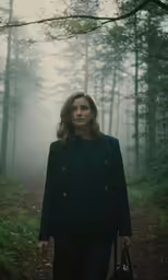 the woman is walking along a trail with a bag