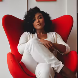 an attractive woman sitting in a red chair