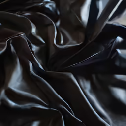 the sheet that lies on top of a black bed