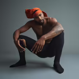 the man is posing with his hand on his knee