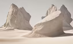 a desert scene with large rocks and small snow mounds