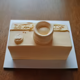 a birthday cake with a camera on the top