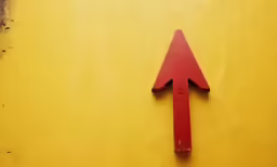 a red piece of wood with an arrow cut in it