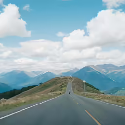 a view of a scenic road and mountains in the distance