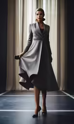 a woman standing in front of a window in grey