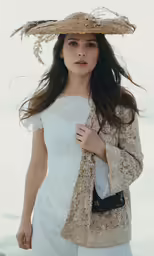 a woman in a white dress and straw hat holding her purse