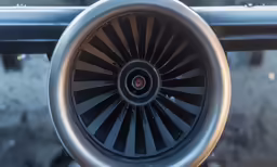 a turbine of a plane sits in the sky