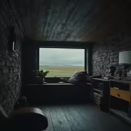 a room with stone walls and flooring is lit by the window