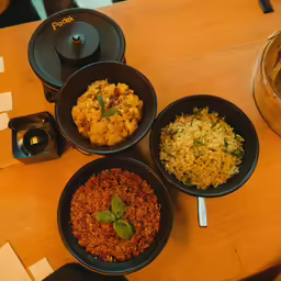 four plates on the table with various food