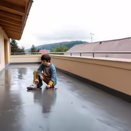 a boy is playing on the floor on a roof