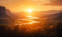 the sun sets over the river surrounded by mountains