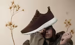 a man holds up his shoe on top of his head