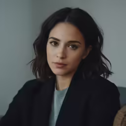 a woman with long dark hair in a black jacket