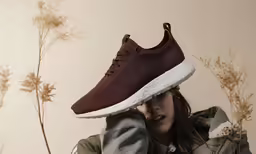 a woman hides her head behind a pair of adidas running shoes