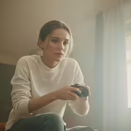 a woman sitting on the floor looking at her camera