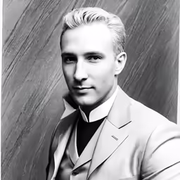 a man in a suit looks into the camera