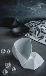 two black and white plates, a bowl with a spoon, and four clear crystal shards