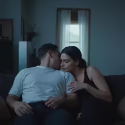 a couple cuddling on the couch and touching noses