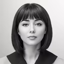 a black and white image of a woman wearing a necklace