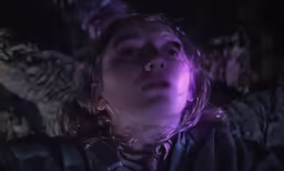 a person with a head piece on stares upwards