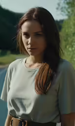 a woman is standing in front of a field and a road