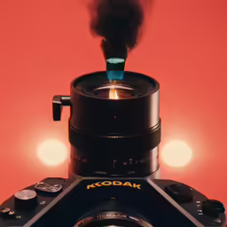 the small fire is rising out of a large camera lens