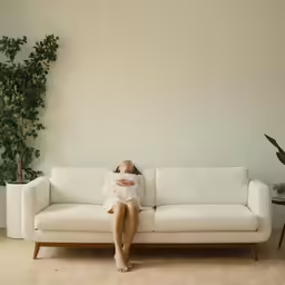 woman resting on white couch in living room