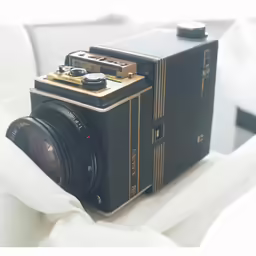 a camera sitting on top of a white sheet