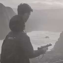 a man standing by the ocean holding a gun