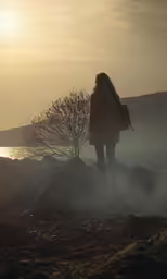 a person in a winter coat looking out to sea