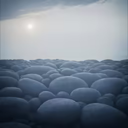 the photo shows the setting of a sunlit sky over rocks