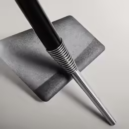 a black pen sitting on top of a stone slab