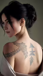 a woman has a large tattoo on her back