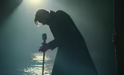 the singer is holding a microphone in his hand