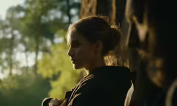 a beautiful woman in black shirt standing by trees