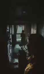 someone is in the dark alone and looking out of a window
