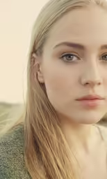 the blonde haired girl with blue eyes is staring at the camera