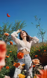 a woman in white crop top sitting down on flower