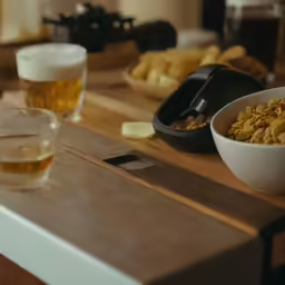 a close up of a bowl of cereal next to a glass of beer