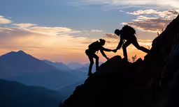 a couple of people are helping each other up a mountain